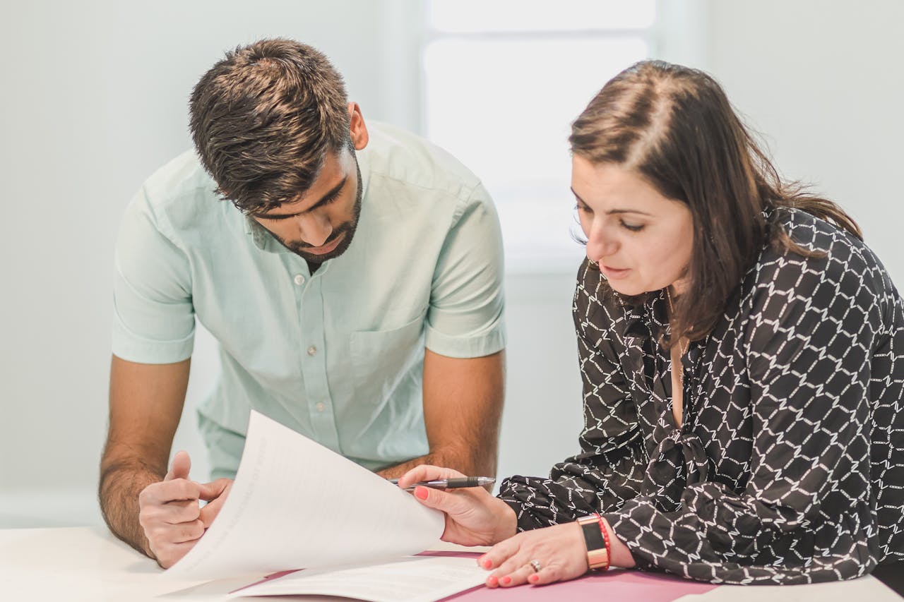 Man and Woman Looking at the Documents